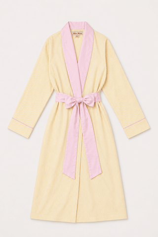 A pale yellow cotton robe with a contrasting light pink collar, belt, and cuff trim, featuring a matching pink tie belt.